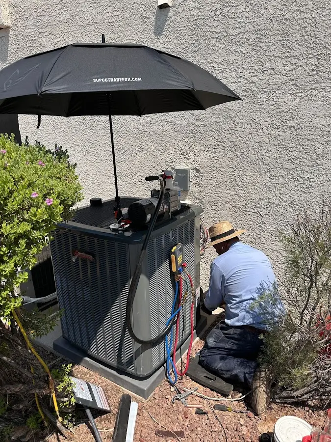 HVAC technician performing outdoor AC maintenance in Lafayette