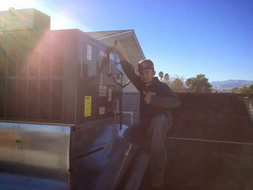 HVAC technician performing AC Tune-Up on a rooftop unit in Lafayette